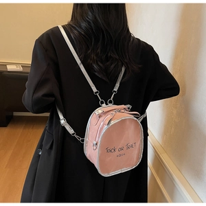 Roze mini rugzak met transparant venster en zilveren riemen op een vrouwelijk model