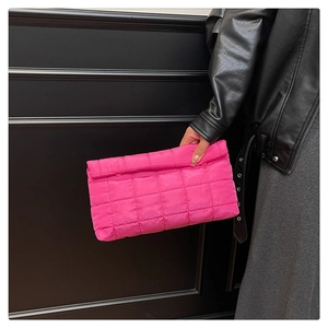 Macro detail van de roze gewatteerde stoftextuur en stiksels op de compacte clutch