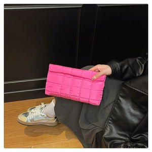 Detailopname van de neonroze clutch met modieuze ruitvormige stiksels en textuur
