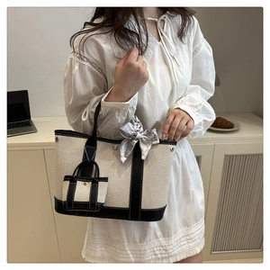 Detail of cream canvas tote bag with black leather trim, silk scarf and mini coin purse