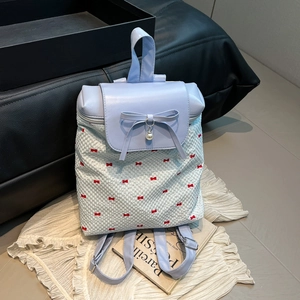Polka dot backpack with blue leather flap and bow accent for school girls