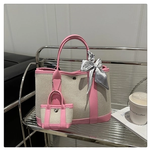 Detail of canvas tote bag with pink leather trim, silk scarf accessory and small pouch
