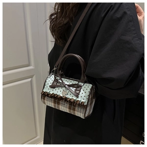 Detail of blue star and plaid fabric shoulder bag with bow and heart pendant
