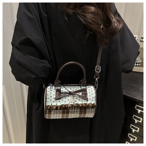 Detail of vintage bow shoulder bag with plaid pattern and star print shown on a model
