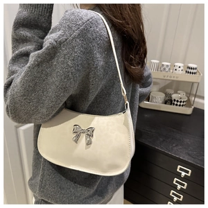 Détail du sac beige avec boucle papillon argentée et motif léopard ton sur ton