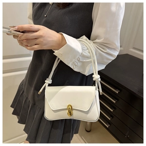Detail der weißen Mini-Tasche mit goldener Schnalle und geknotetem Schultergurt