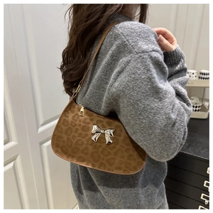 Détail du sac à bandoulière léopard en daim avec un grand nœud en métal argenté