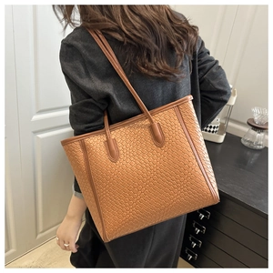 Brown woven texture tote bag detail showing large capacity and slim shoulder straps