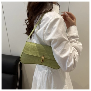 Detail view of light green crocodile pattern underarm bag with gold metal buckle