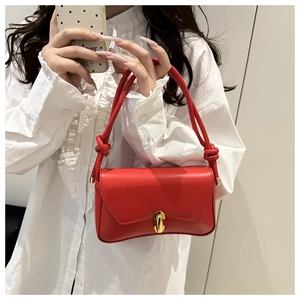 Details der roten matten Lederhandtasche mit goldenem Drehverschluss und Knotengriff