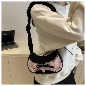 Détail du sac cabas en nylon rose plissé avec volants noirs, ruban et pendentif cœur