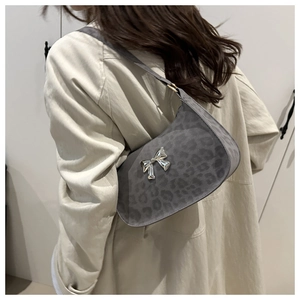 Détail d'un sac hobo à motif léopard gris avec une boucle papillon argentée décorative