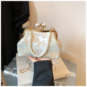 Detailed view of blue brocade embroidery bag with pearl clasp and chain strap
