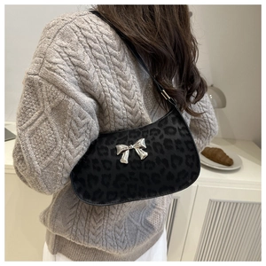 Détail du sac sous l'aisselle à motif léopard noir avec un nœud en métal argenté