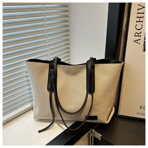 Dettaglio della borsa tote in tela beige con tracolla nera e interno capiente
