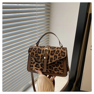 Detail of leopard print crossbody bag with faux calf hair and golden buckle closure