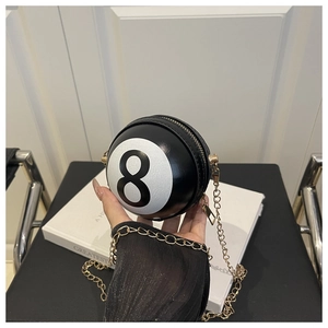 Detailed close-up of a black and white billiard number 8 spherical bag with a gold chain strap