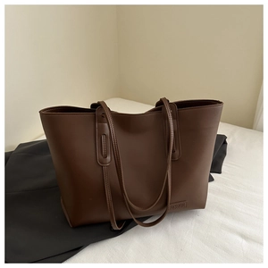 Dettaglio della borsa tote marrone scuro con etichetta Fashion e pelle sintetica PU liscia