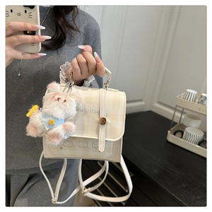 Dettaglio mini zaino a quadri color crema con stampa orso e ciondolo a forma di coniglio