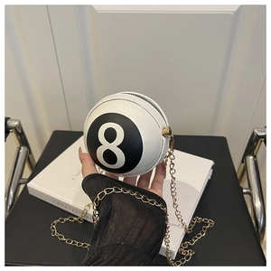 Detail of spherical billiard-inspired crossbody bag with golden chain and black 8 motif
