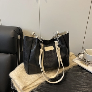 Large black quilted tote bag with cream straps and silver chain detail for daily commute