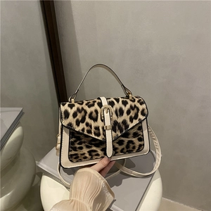 Chic leopard print handbag with cream leather trim shown from a stylish front angle