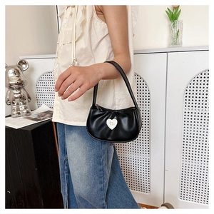 Detail of a black mini PU leather handbag with heart-shaped NY logo on the front