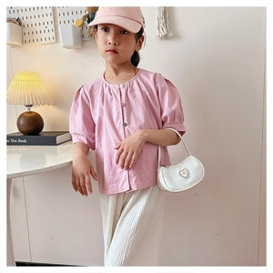 Pink short sleeve cotton shirt and white pleated trousers styled for a girl's casual look