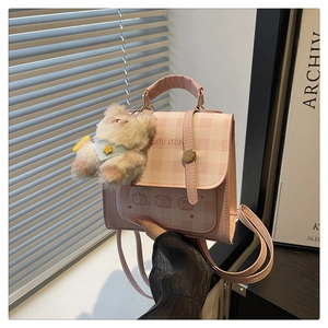 Dettaglio borsa a quadretti rosa con motivo cucciolo e ciondolo a forma di alpaca peluche