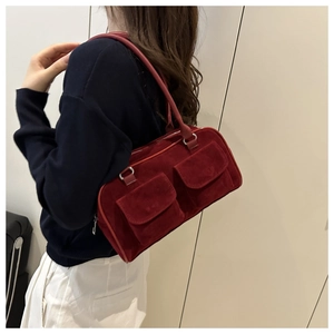 Detail of dark red suede underarm bag with double utility pockets on a model