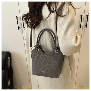 Detail of leopard print bucket bag with gold ring hardware and logo print text