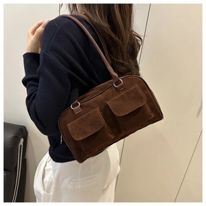 Détail du sac bandoulière vintage en daim marron avec deux poches à rabat et sangle en cuir