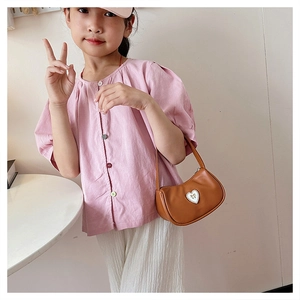 Close-up of brown PU leather girls' heart-shaped handbag with adjustable shoulder strap