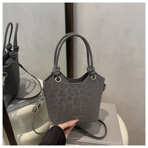 Detail of grey leopard print bucket bag with knotted handle and golden brand logo