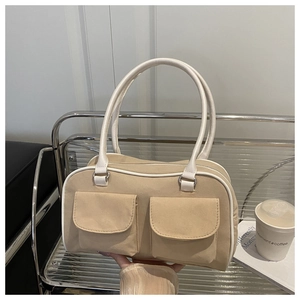 Détail du sac Boston beige minimaliste avec poches avant et passepoils blancs contrastés