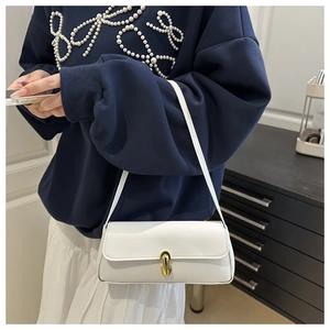 Detail view of a white textured leather underarm bag featuring a elegant gold buckle