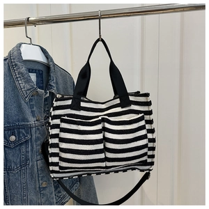 Detail of striped canvas tote bag with front double pockets and detachable shoulder strap