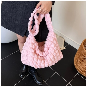 Detail shot of a pink bubble pleated crossbody bag with soft cloud texture style