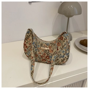 Close-up of retro floral jacquard crescent bag with elegant gold metal plate detail