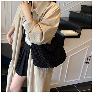 Detail of black puffer shoulder bag with quilted cloud texture and spacious design