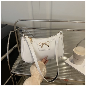Detalle del bolso de hombro de PU blanco brillante con lazo metálico dorado y cremallera