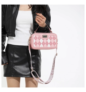 Detailed view of pink crossbody bag with diamond quilting and geometric wide strap
