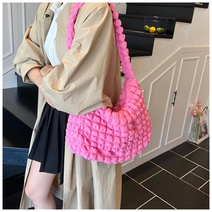 Detailed texture of vibrant pink popcorn fabric on a large capacity crescent shoulder bag