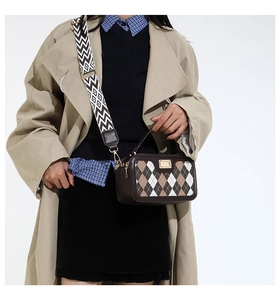 Detail of vintage plaid handbag featuring argyle pattern and stylish woven crossbody strap