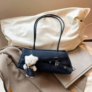 Denim underarm shoulder bag with black leather cross straps and a cute plush bear pendant