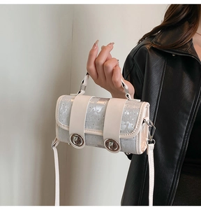 Detail of silver sequined mini square bag with dual metal turn-lock closures and handle