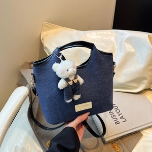 Blue denim underarm bag with black leather handle and cute white bear charm
