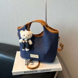 Vintage blue denim tote bag with brown leather trim and cute plush bear charm
