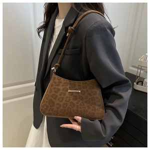 Détail du sac sous l'aisselle à motif léopard avec bandoulière nouée et métal