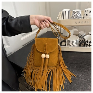 Dettaglio della borsa a tracolla boho in camoscio zenzero con lunghe frange e perline